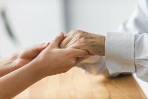 nurse holding senior man s hands for comfort Radio televizija Rožaje